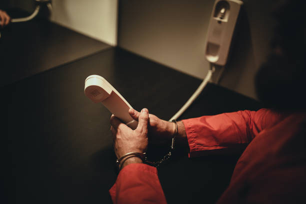 Inmate holding phone to make jail call